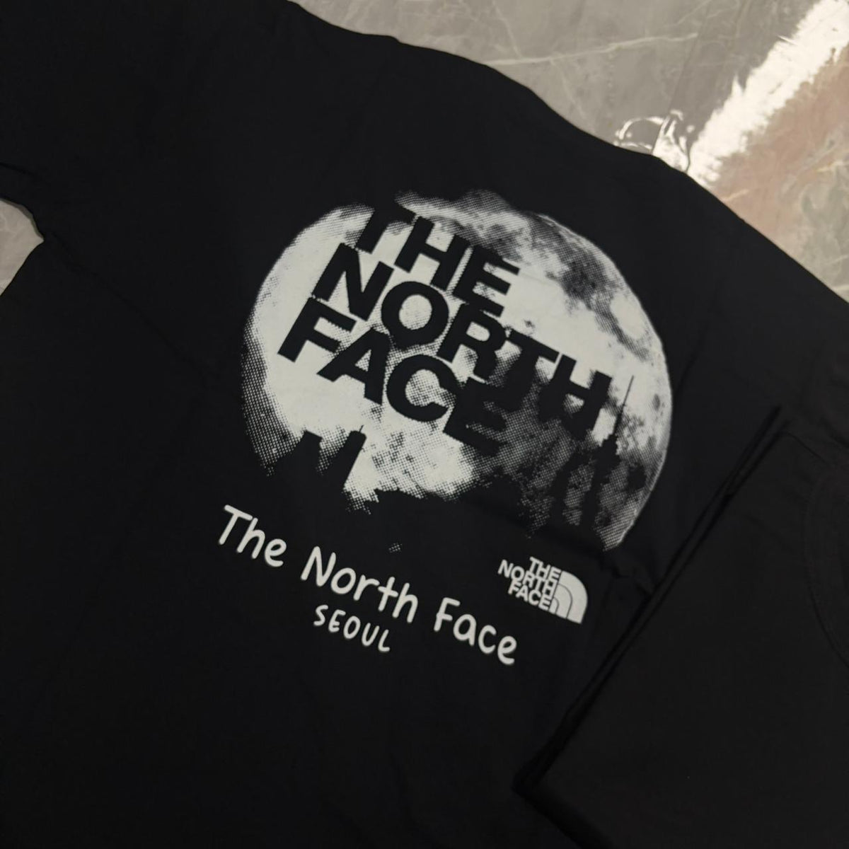Camiseta Grife The North Face Preta Edição Seul com Estampa Lunar Branca