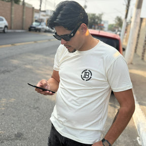 Camiseta Grife Balmain Off-White/Creme com Logo Estilizado Fluorescente nas Costas e Minimalista na Frente